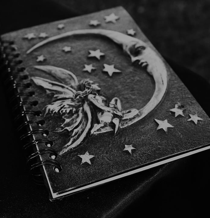 Decorative notebook featuring a fairy and crescent moon design with stars on the cover.