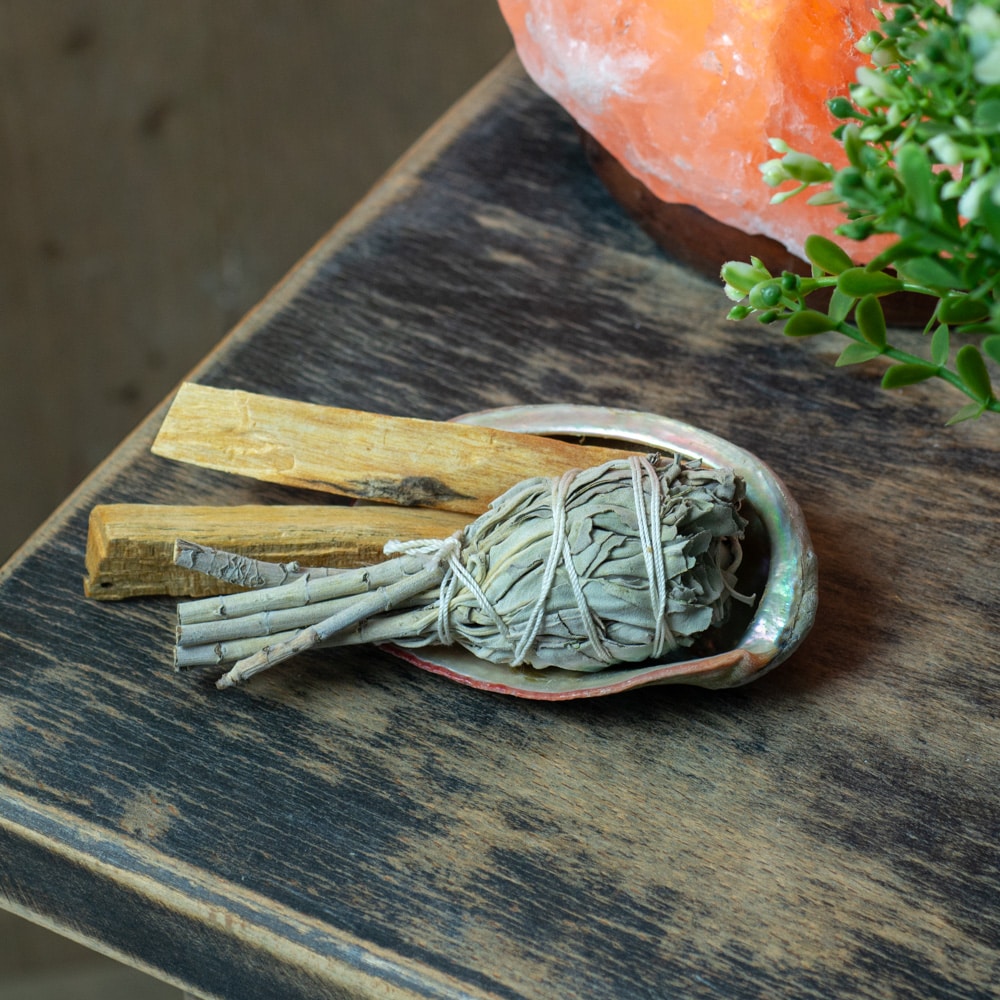 witte salie smudge stick palo santo op abalone schelp