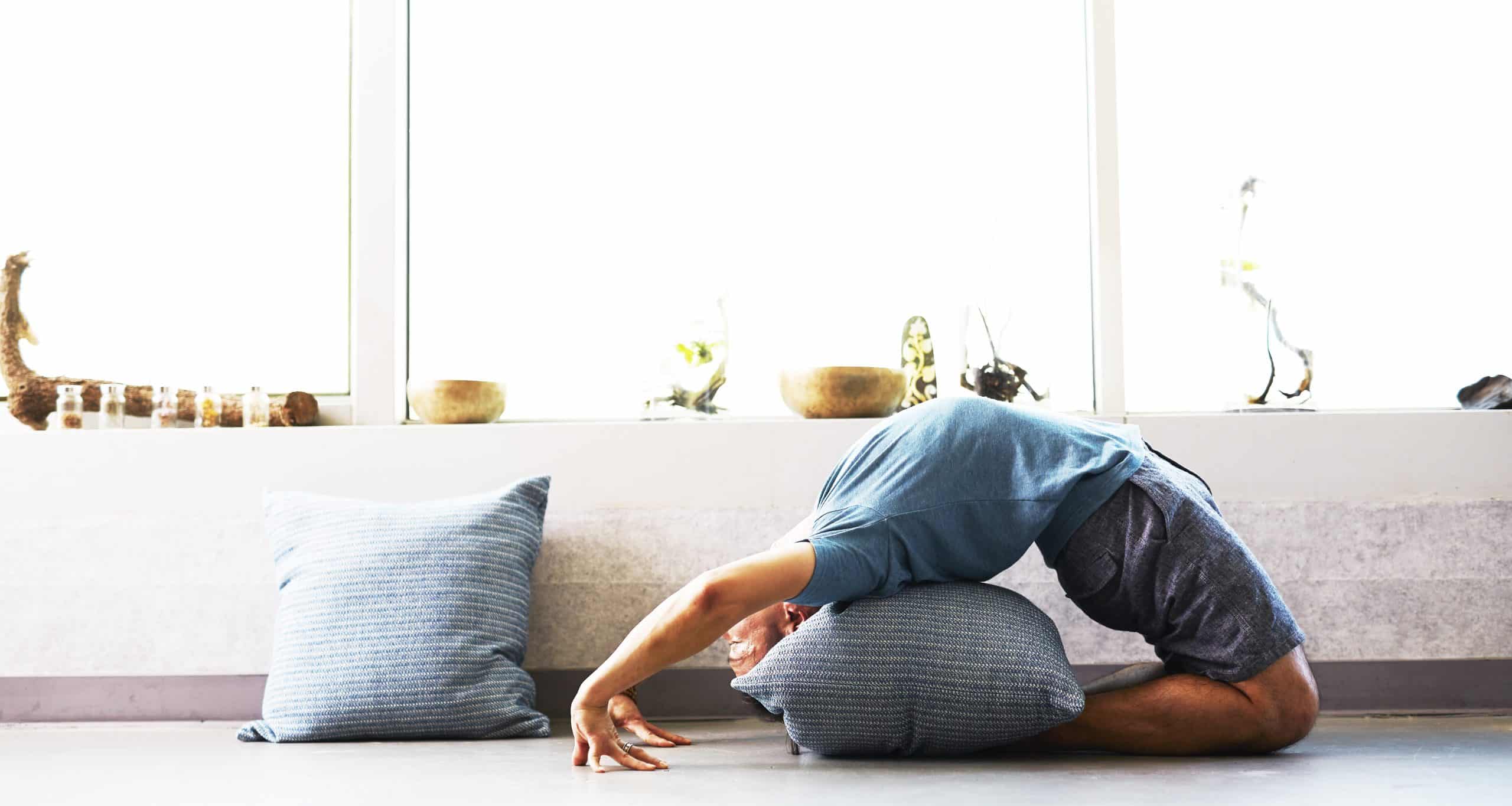 man yoga pose met kussen