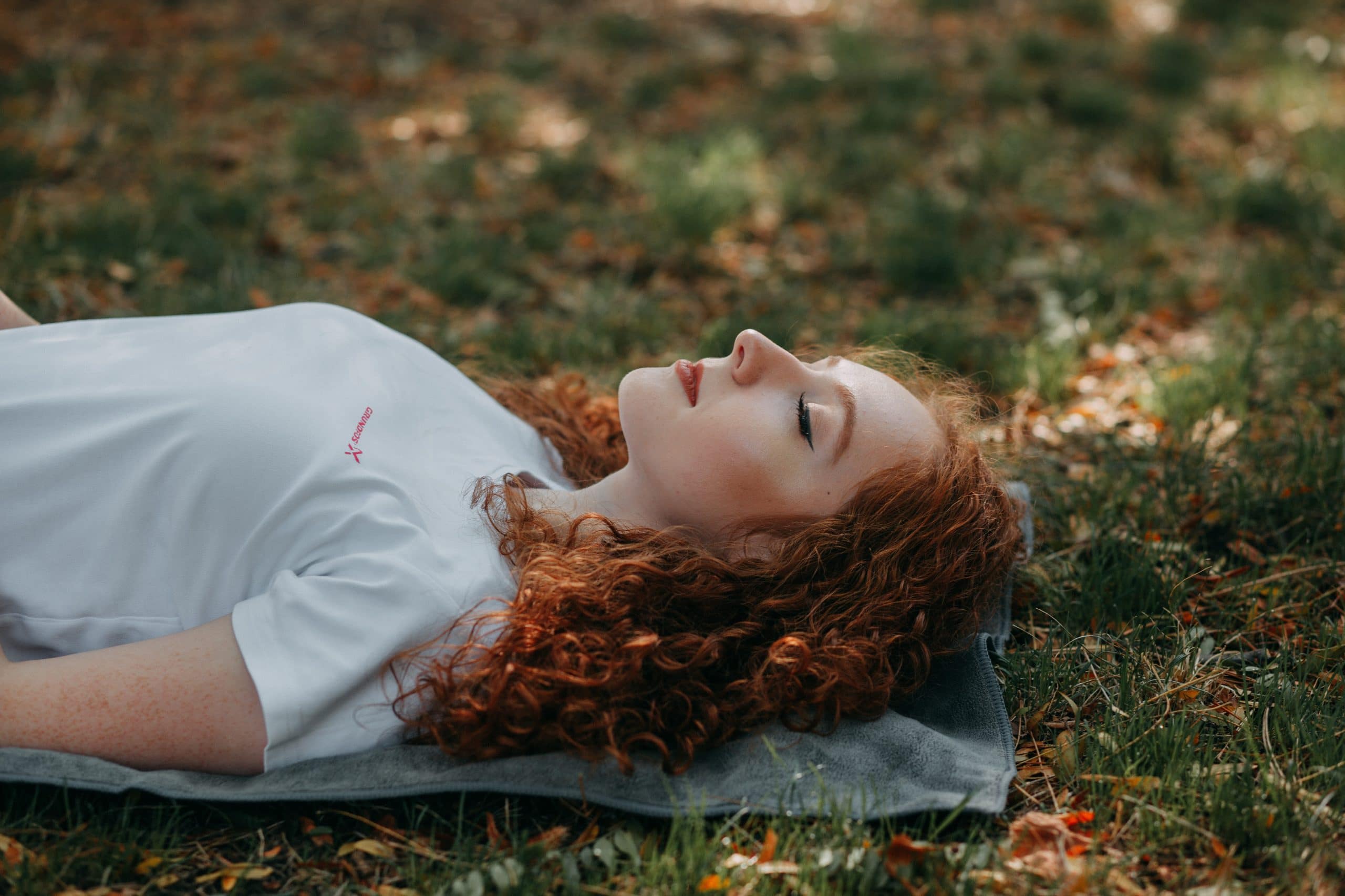 vrouw ligt in gras ogen dicht